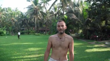 Young man practicing yoga in the national park, smooth flight of the camera