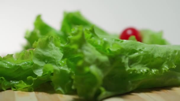 Świeże liście sałaty na kuchennej desce. Zbliżenie — Wideo stockowe