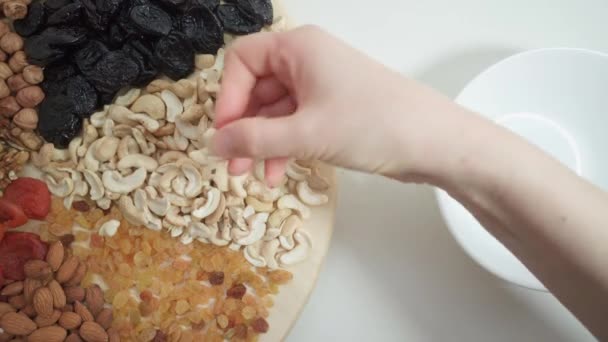 A person chooses nuts and dried fruits. Healthy food. — Vídeo de Stock