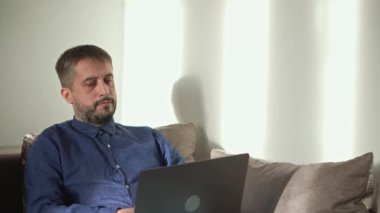 Orta yaşlı bir adam işten sonra rahatlamak için internette sörf yapar..