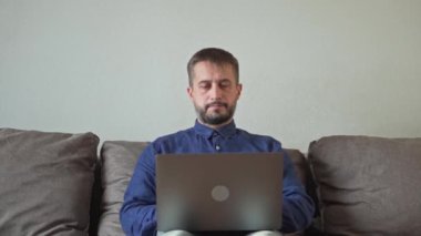 Bir adam dizüstü bilgisayarla çalışıyor. Stres, baş ağrısı, umutsuzluk