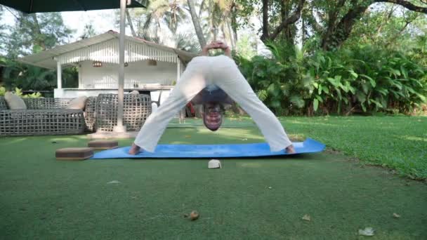 Щоденна практика йоги. Гуру йога. Чоловік у білих штанях — стокове відео