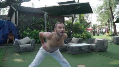 Beyaz bir adam yoga yapıyor. Halk parkı. Günlük yoga dersi