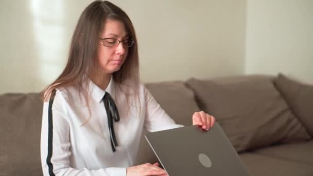 Trabalhar online. A rapariga trabalha em casa. Trabalhando em um laptop — Vídeo de Stock