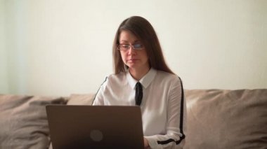 Evde yetişkin bir adam var. Mesai bitti. Bir dizüstü bilgisayar kullanarak.