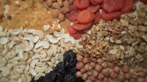 Round table filled with nuts and dried fruits. The benefits or harms — Stock Video