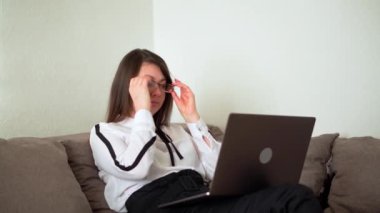 Kadın bilgisayardaki uzun bir çalışmadan sonra yorgun. Evde serbest çalışmak..