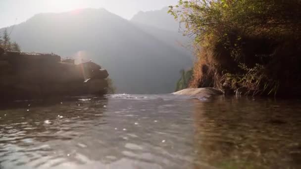 Krawędź wodospadu. Promienie słońca wypełniają górski krajobraz — Wideo stockowe