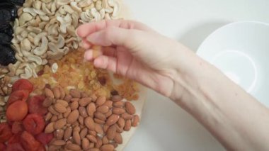 Bir insan kurutulmuş kayısı ve fındık seçer. Vejetaryenlik