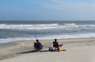 Chincoteague, Virginia, ABD - 21 Eylül 2021 İnsanlar sahilde balık tutuyor.