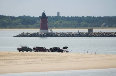 Lewes, Delaware, ABD - 21 Eylül 2021 Cape Henlopen Sahili 'ndeki deniz fenerine bakan balıkçı ve kamyonların manzarası