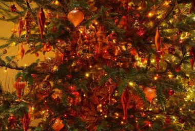 Kırmızı kurdeleler, ışıklar ve süslemelerle süslenmiş güzel Noel ağacı