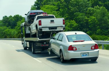 Kentucky, U.S.A - August 20, 2021 - Two cars and a pick-up truck being towed by a large truck