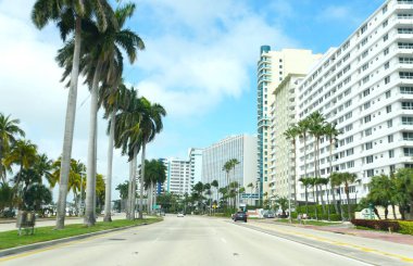 Miami Beach, Florida, ABD - 17 Şubat. 2022 - Collins Bulvarı 'ndaki yüksek binalı ve apartmanlı yol manzarası