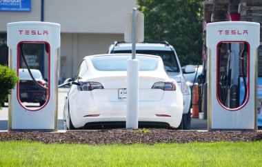 Lewes, Delaware, ABD - 30 Mayıs 2022 Şarj istasyonlarında beyaz bir Tesla Model 3 sedan