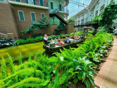 Nashville, Tennessee, U.S - June 26, 2022 - Visitors on the river boat surrounded by tropical plants inside of Gaylord Opryland Resort and Convention Center