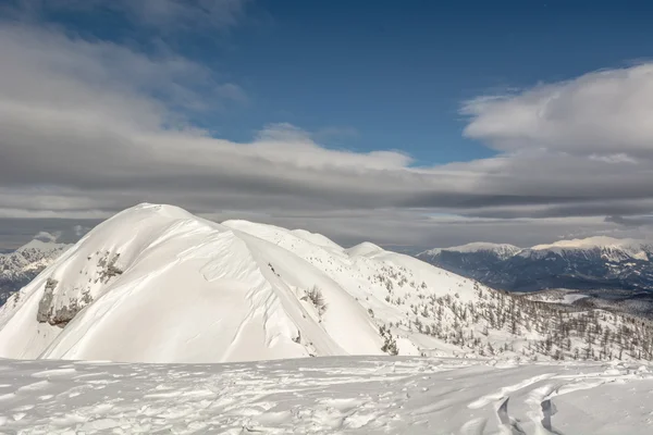 Bergtop met ski tracks toonaangevende omlaag — Stockfoto