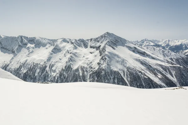 Verschneiter Hang mit Bergrücken im Rücken — Stockfoto