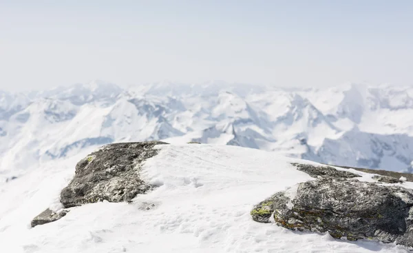 Sněhem pokryté rock s mountain view v zádech — Stock fotografie