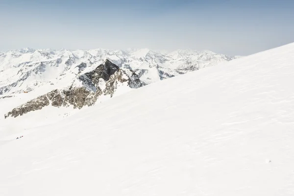 後ろの山の尾根と雪に覆われた斜面 — ストック写真