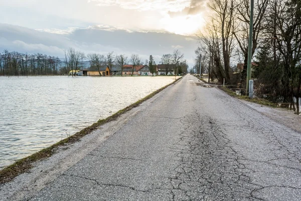 Strada che corre lungo il campo allagato — Foto Stock