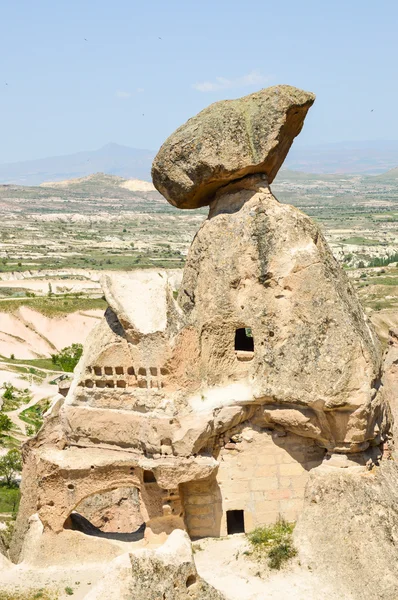 Cave dwelling with huge rock tilting on the top — Stock Photo, Image