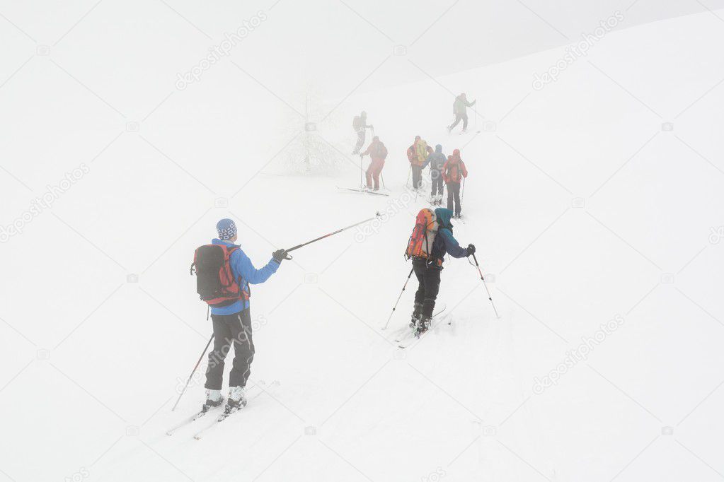 Backcountry skiers ascending in the fog