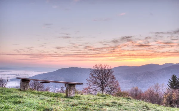 Сидя на скамейке с восходом солнца — стоковое фото