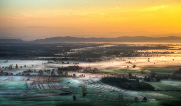 Sunrise above fields covered with morning mists — Stock Photo, Image