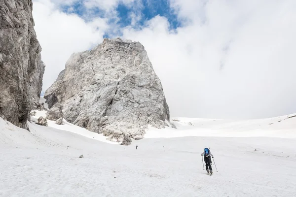 Esquiadores subiendo la pendiente de la montaña —  Fotos de Stock