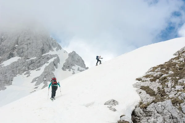 Skieurs montant la pente de montagne — Photo