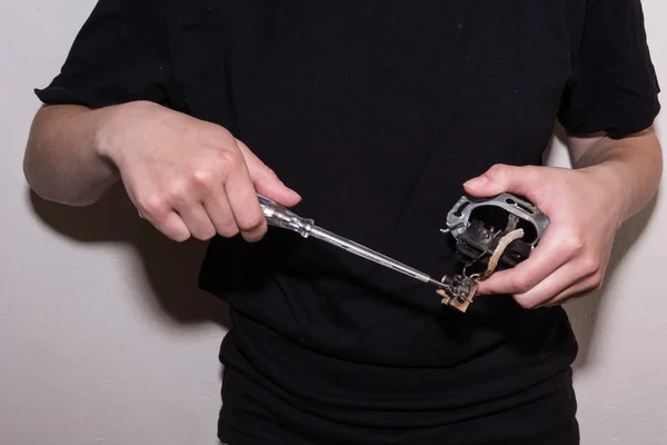 Person using a screwdriver on a damaged socket — Stock Photo, Image