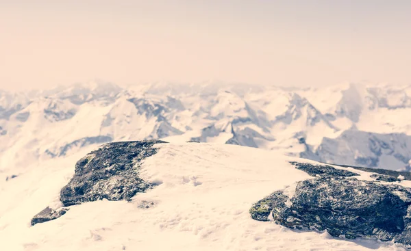 Sněhem pokryté rock s mountain view v zádech — Stock fotografie