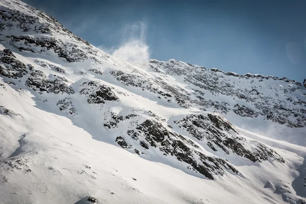 Crête de montagne avec vent soufflant de la neige — Photo