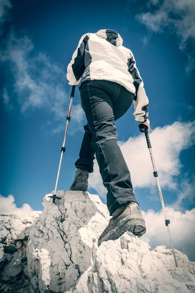 Jeune femme montant une crête de montagne — Photo