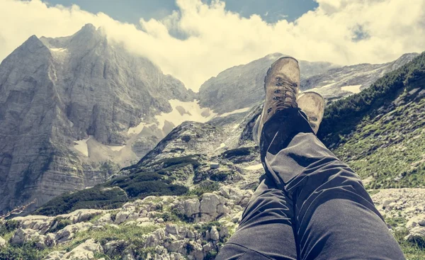 Par de pernas esticadas no ar com vista para a montanha — Fotografia de Stock