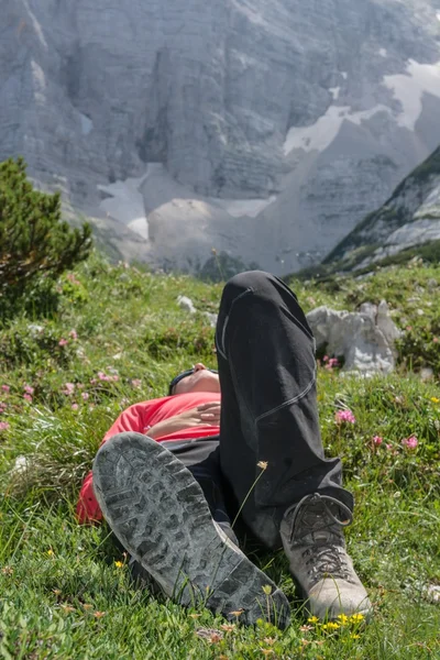 Junge Frau entspannt auf einer Bergwiese — Stockfoto