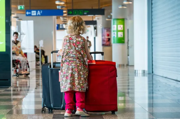 Cute blondynka dziewczyna z bagażu podróżnych na lotnisku. — Zdjęcie stockowe