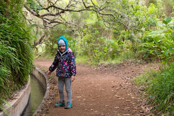 Cute young girl hiking along forest path. — Fotografia de Stock