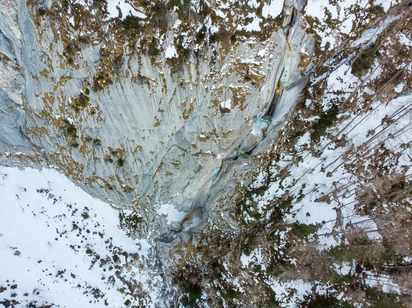 Spektakulär antenn utsikt över fruset vattenfall faller över klippkanten under vintern. — Stockfoto
