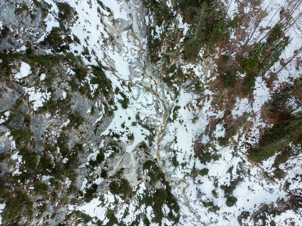 Drop down view of a mountain river flowing through winter forest. — Stock Photo, Image