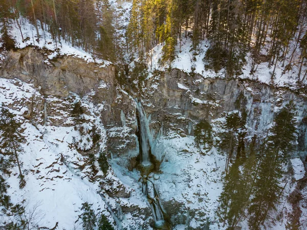 바위투성이 숲의 가장자리 위로 떨어지는 폭포의 웅장 한 폭포 광경. — 스톡 사진