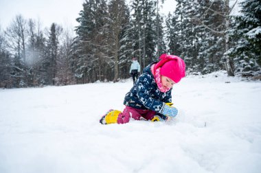 Soğuk bir sabahta karla oynayan tatlı bir kızın portresi..