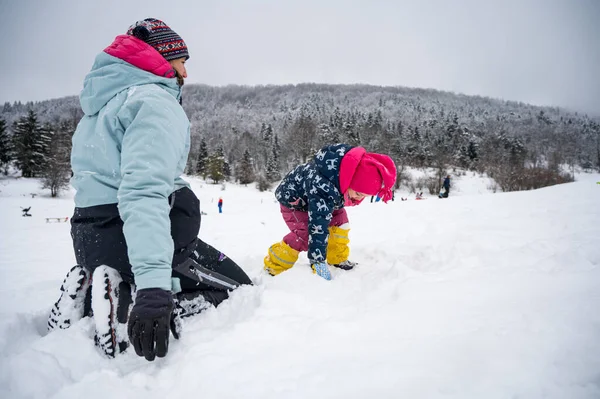 Moeder en dochter plezier in de sneeuw. — Stockfoto