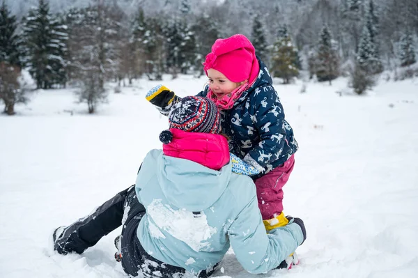 Moeder en dochter plezier in de sneeuw. — Stockfoto