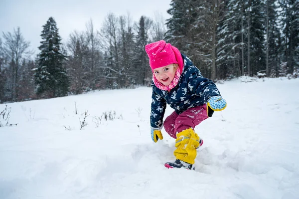 Lachend meisje klaar om een gevecht te beginnen met sneeuwballen. — Stockfoto