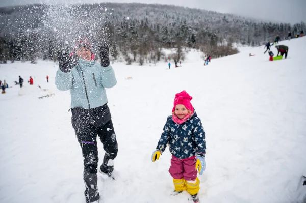 Мати і дочка розважаються в снігу . — стокове фото