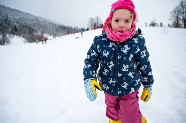 Szomorú lány rózsaszín kalapban a havas lejtőn. — Stock Fotó