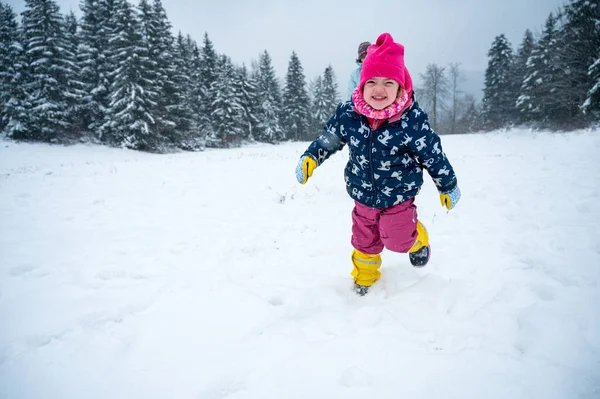 Gelukkig meisje rennen over vers gevallen sneeuw. — Stockfoto