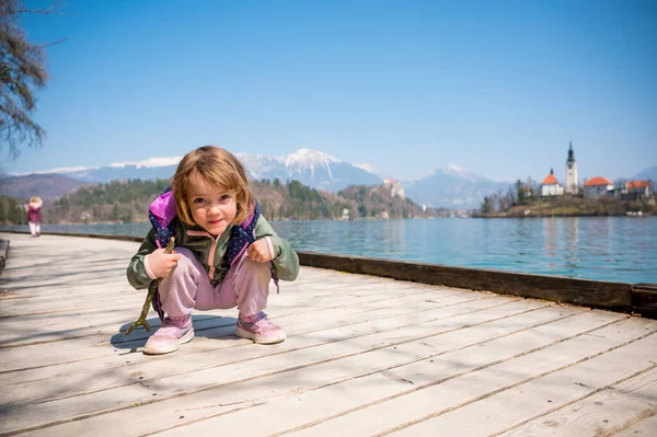 Menina loira bonito posando em uma costa do lago Bled explorando vistas eslovenas. — Fotografia de Stock